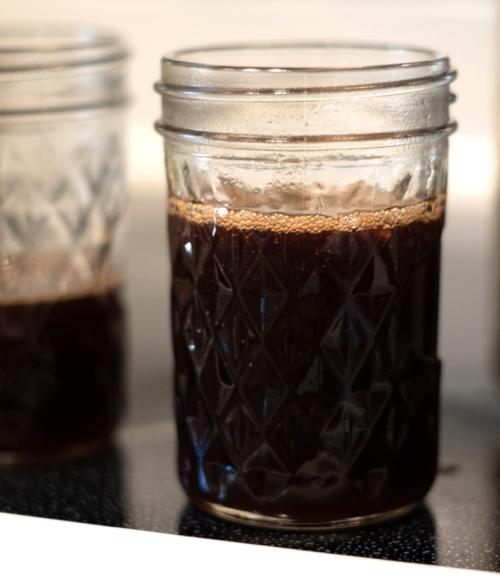 Mason jar full of dark colored cascara jelly